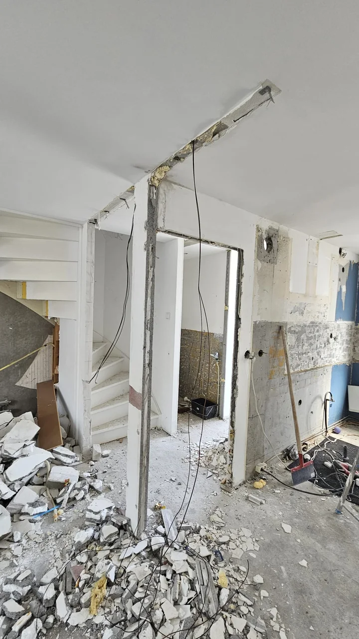 Voor: muur gesloopt, puin op de vloer en losse kabels