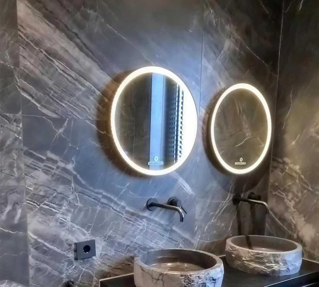Badkamer in donker marmer met ronde spiegels