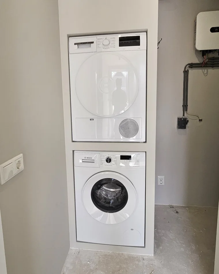 Wasmachine en droger gestapeld in een maatwerknis